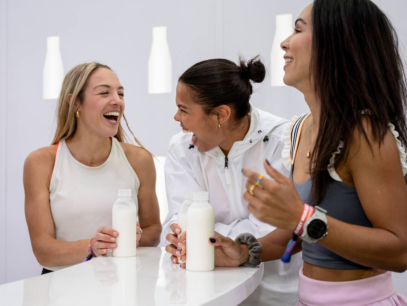 Two women drinking chocolate milk after a long run, in front of the Chicago River, during sunset.